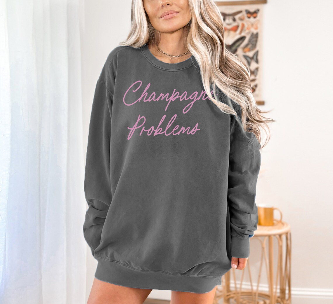 Champagne Problems crew neck sweater on dark gray sweater